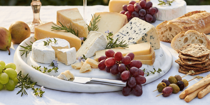 Best charcuterie board with cheese, grapes, crackers, nuts, and figs arranged on a wooden serving board for an elegant food presentation.